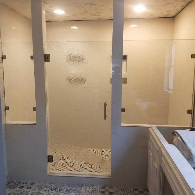 A bathroom with a walk in shower next to a sink