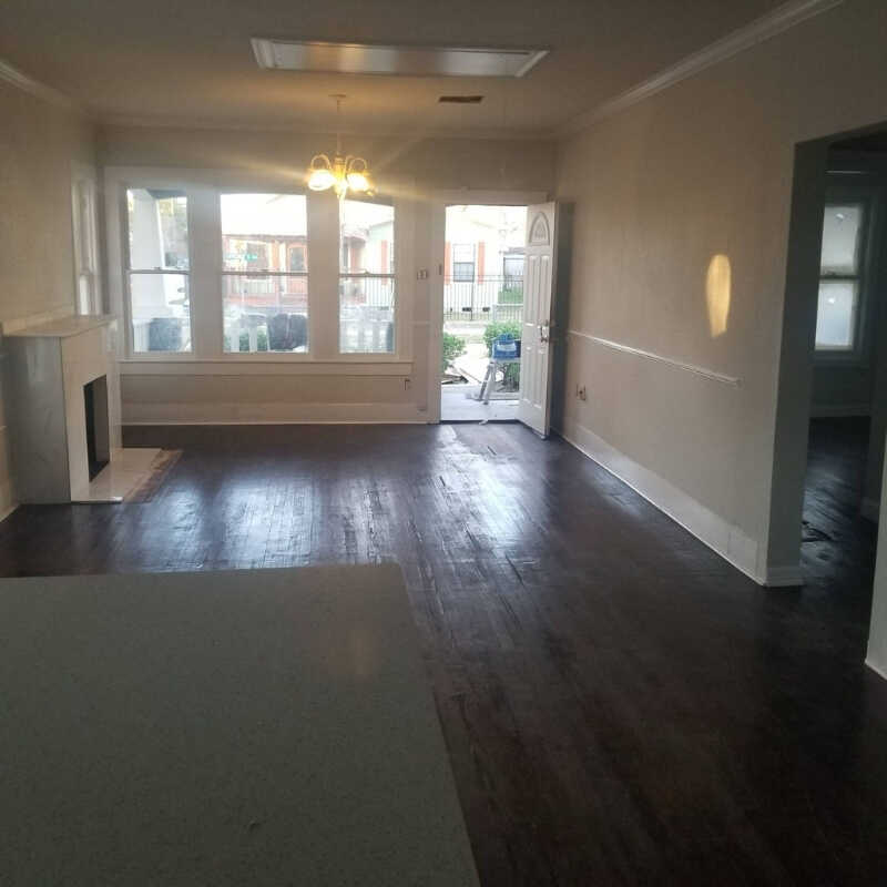 An empty living room with hard wood floors